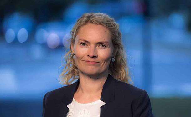 Kvinne i svart genser og blå blazer
